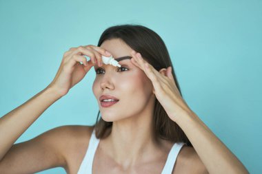 Göz bakımı, vizyon ve sağlık. Kuru gözler ya da göz tahrişi için göz damlası kullanan bir kadının yakın çekimi. Sağlık ve Kişisel Bakım Rutini.