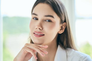 Genç kadın, yumuşak gülüşlü ve uzun saçlı. Kendine güveni ve sükuneti parlak, doğal bir geçmişe yayar. Güzellik, kendine güven ve sükunet kavramları için mükemmel..