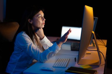 Ofis masasında geç saatlere kadar çalışan Odaklanmış Kadın