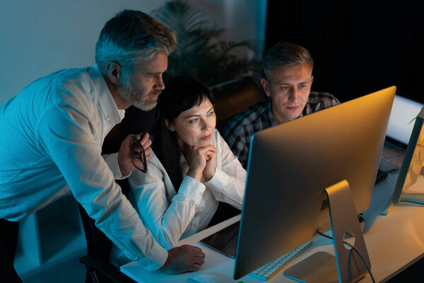 Team Professionals Working Late Night Office Focused Intent Computer Screen Stock Picture