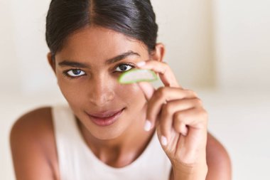 Aloe Vera Dilimini Tutan Kadın Doğal Güzellik ve Cilt Bakımı Yapıyor. Bitkisel sağlık ve organik tedavi çözümlerine odaklanarak tazelik, sağlık ve hidrasyon yayar..