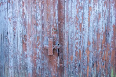 Eski ahşap kapı maviye boyanmış, yıpranmış.