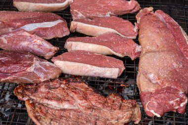 Organik sığır eti parçaları barbekü ızgarasında pişirmeye hazırdır.