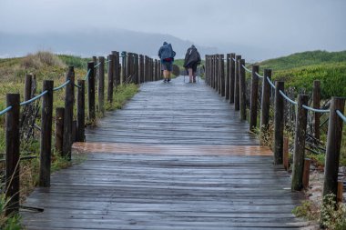 pilgrims to Santiago de Compostela on a rainy day along the Portuguese coastal route clipart