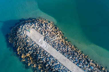 Sakin denizi ve turkuaz suyu olan bir dalgakıran manzarası