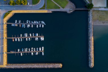 Bir marinaya yanaşmış birkaç teknenin zenital hava görüntüsü.