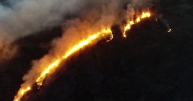 Alacakaranlıkta çıkan orman yangınının hava görüntüsü.