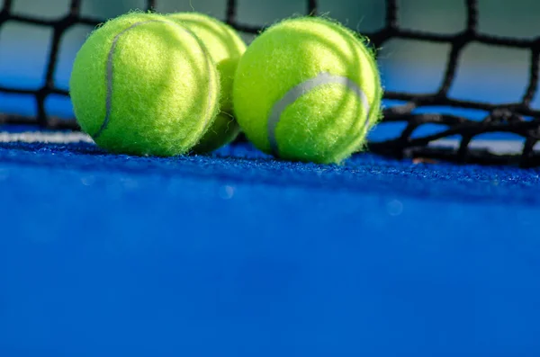 seçici odak, raket tenis kortunun yanındaki üç topun zemin katı görünümü