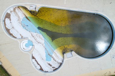 Terk edildiği için kirli suyu olan bir havuzun havuz manzarası.