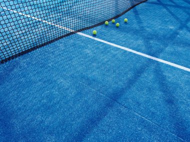 Mavi bir çim küreğindeki beş topun görüntüsü tenis kortunda
