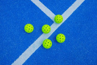 Mavi bir saha çizgisinin yanında beş tane yankesicilik topu