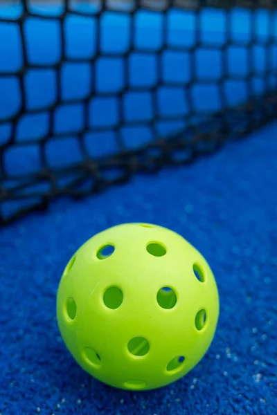 Seçici odaklanma. Mavi bir sahada, kalenin yanında bir picleball topu.