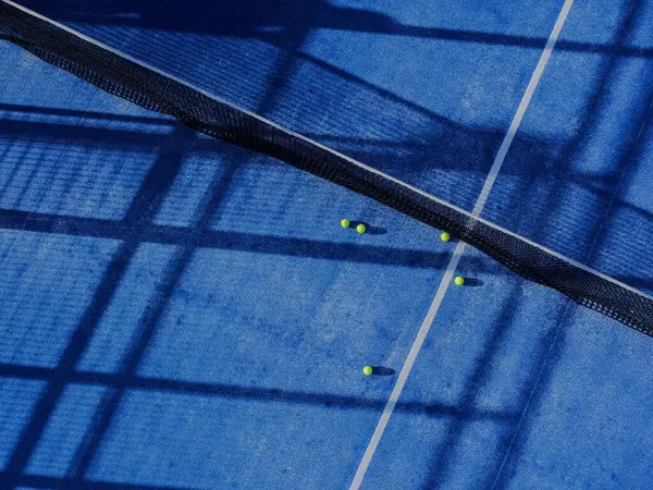 Raket tenis kortunun hava aracı görüntüsü ve beş top.