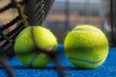 Raket tenis kortunun arkasındaki iki topun seçici odak noktası.