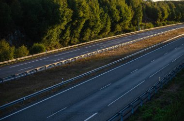 view of a highway with no traffic at sunset clipart