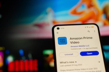 Madrid İspanya 09: 25 2023: Amazon Prime Video uygulama yükleyicisi akıllı telefonda ve bilgisayar ekranı arka planda. Talep üzerine akış konsepti.