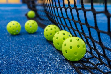 Ağ tabanında yeşil picleball topları, yeni raket sporu