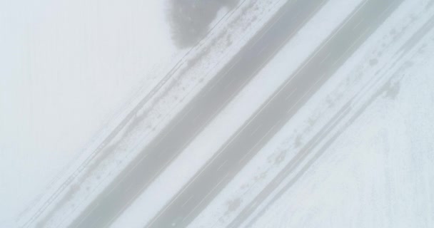 雪の日に霧のような高速道路を運転する車 ドローンの映像 — ストック動画