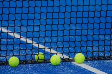 Mavi raket tenis kortunda dört top, raket sporu konsepti