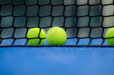 Seçici bir odak, iki top ve bir raket tenis kortu ağı. Raket sporları konsepti