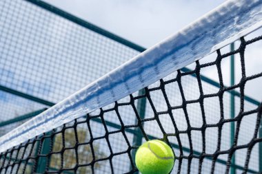 Top raket tenis kortunun ağına çarptı, raket sporu konsepti.
