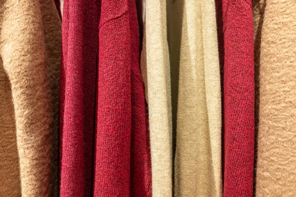 Seçici odak, butikte askılardan sarkan yün kazaklar.