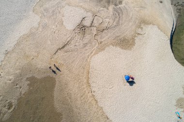 Yaz mevsiminde insanlarla dolu bir sahilin insansız hava görüntüsü.