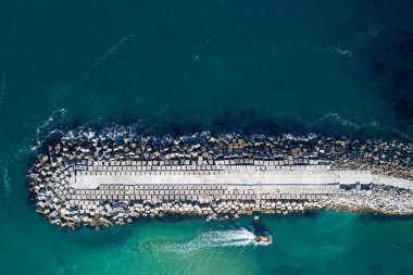 Bir geminin ve liman dalgakıranının zenital hava aracı görüntüsü