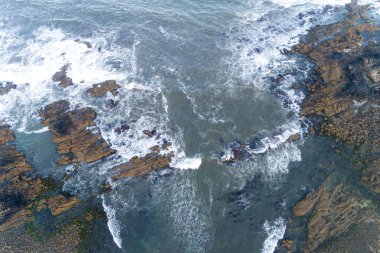 İnsansız hava aracından görülen kayalık kıyı şeridi, zenital görünüm