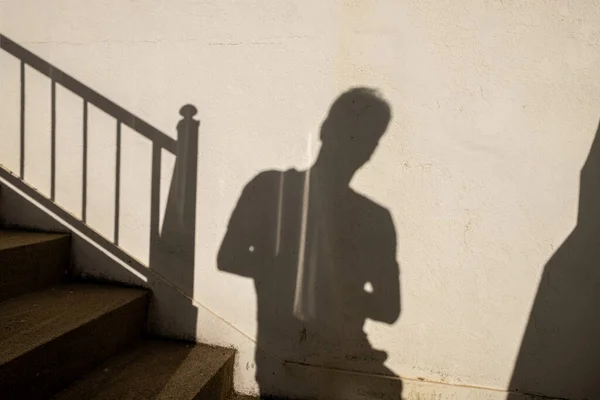 shadow of an adult man on a wall.