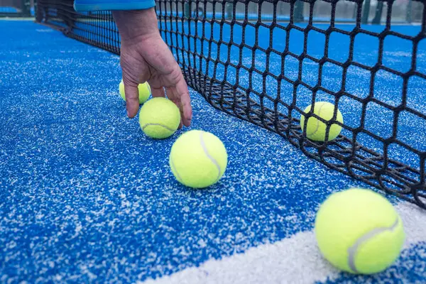 Seçici odaklanma, tenis kortunda top toplayan bir adamın eli.