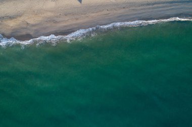 Güneşin doğuşundaki kumsalın insansız hava görüntüsü