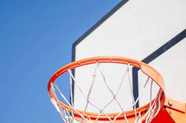 Aşağıdan görülen basketbol potasına yakın, mavi gökyüzü arkaplanı