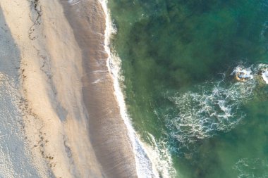 Güneşin doğuşunda kumsalın kumsalını gösteren İHA hava görüntüsü