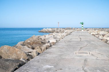 Mavi gökyüzü gününde iki fenerli liman dalgakıranı