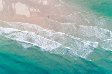 Sabahları kumsalda yürüyen bir adam, yukarıdan bir drone ile hava manzaralı. Yaz konsepti