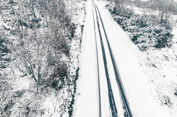 Drone aerial view of a road in a snowy landscape, winter time transportation concept