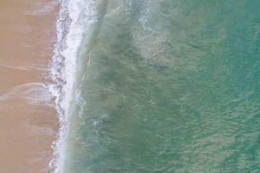 Turkuaz suları olan bir sahil kıyısının zenital hava manzarası