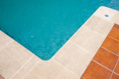 Yüzme havuzunun kenarında beyaz fayanslar var, yaz zamanı.