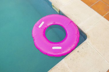 Yüzme havuzunda pembe bir yüzücü manzarası, yaz konsepti.