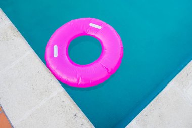 Yüzme havuzunda pembe bir yüzücü manzarası, yaz konsepti.