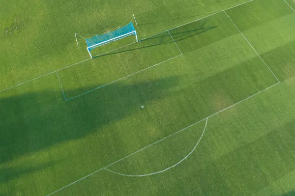 Aerial drone view of a grass football field goal