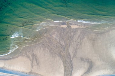 Sabahın erken saatlerinde bir kumsalın hava aracı görüntüsü.