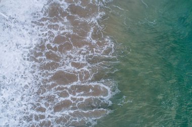 Kumsalın kıyısındaki köpüğün drone hava görüntüsü.