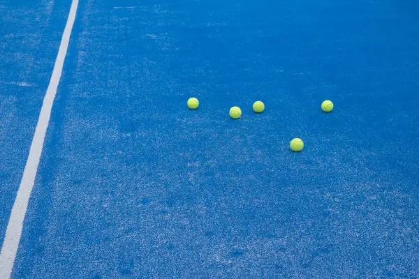 Selective focus. Paddle tennis balls on an open blue paddle tennis court. Racket sports concept