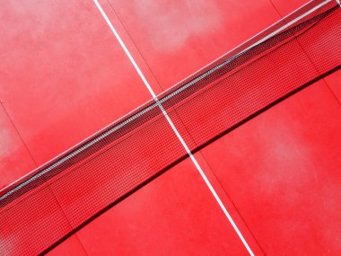 Kırmızı tenis kortunun net ve servis hatlarının üst görüntüsü