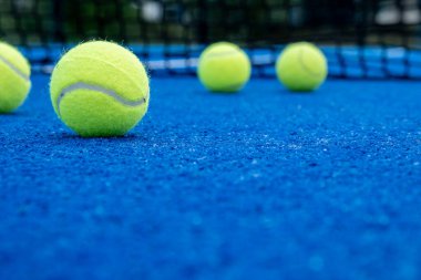 Seçici odaklanma, raket tenis kortunda beş top.
