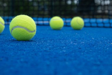 Seçici odaklanma, raket tenis kortunda beş top.