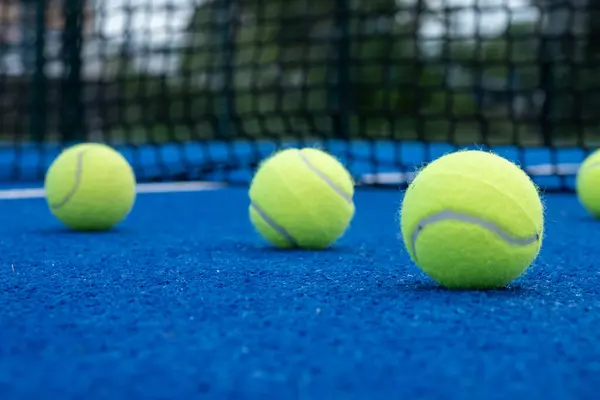 five balls on a paddle tennis court, selective focus,