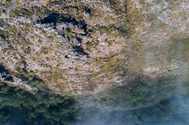Sisli koşullarda bir dağ uçurumunun tepe manzarası